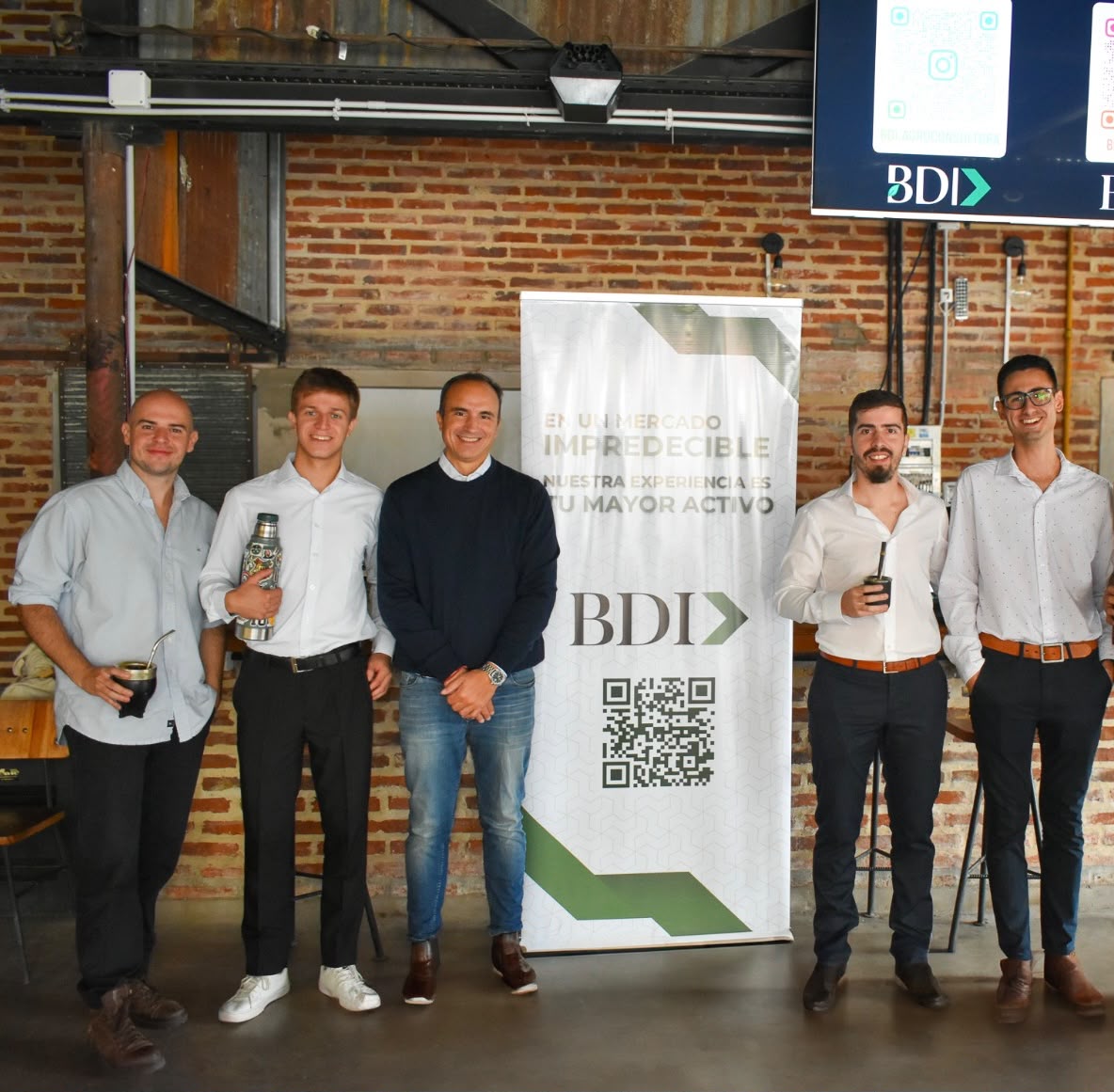 Equipo de BDI Consultora junto al banner institucional